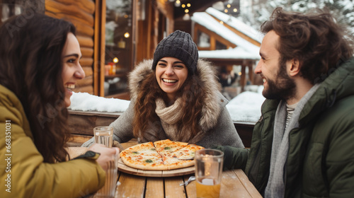 Colleagues or friends eat pizza and chat in a cafe. Wintertime leisure, food and drink, people and holidays concept © Irina Sharnina