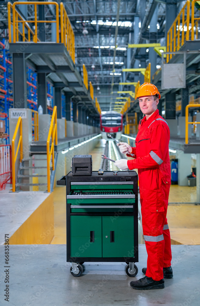 Vertical image of professional technician worker with safety uniform check tools and equipment in the cabinet with look at camera in electrical or sky train factory. Vertical image of professional technician worker with safety uniform check tools and equipment in the cabinet with look at camera in electrical or sky train factory.