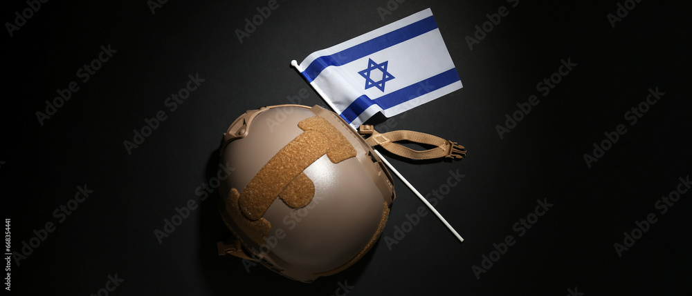 Flag of Israel with military helmet on dark background. Israel-Hamas war