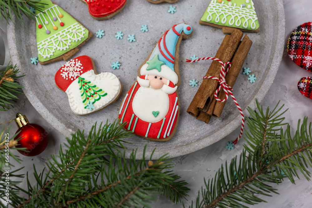 Homemade gingerbread cookies on tray on grunge gray background. Christmas and New Year celebration background. Close up of home baked cookies with icing.