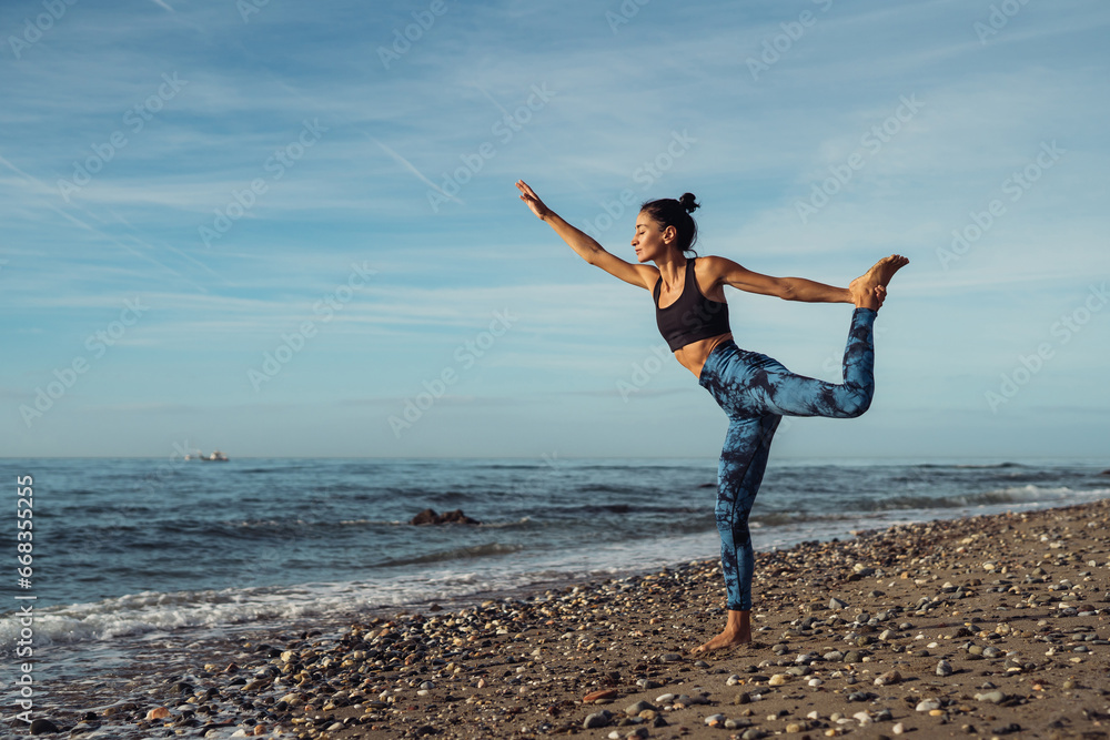 Beautiful athletic brunette girl doing Pilates by the seaside Beautiful athletic brunette girl doing Pilates by the seaside