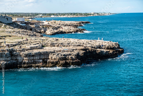  The rocky outcrop opposite the Cala Ponte beach in Polignano a Mare, Italy,, .surrounded by the crystal clear waters of the Adriatic..