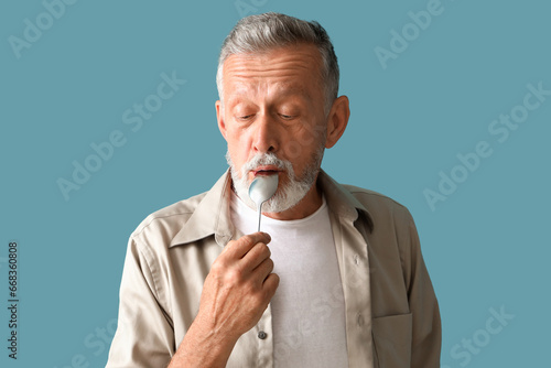 Mature man with spoon on bl...