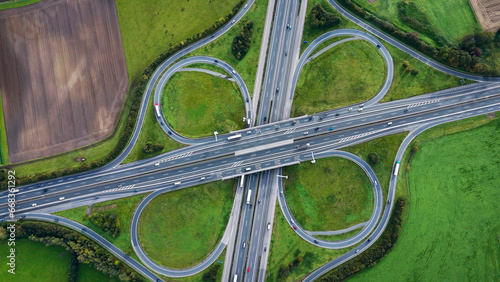Aerial drone view road junction. Clover roundabout view from above. Car traffic on autobahn Germany.