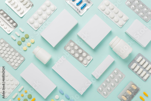 Flat lay with different pills in blister packaging and boxes and on color background photo