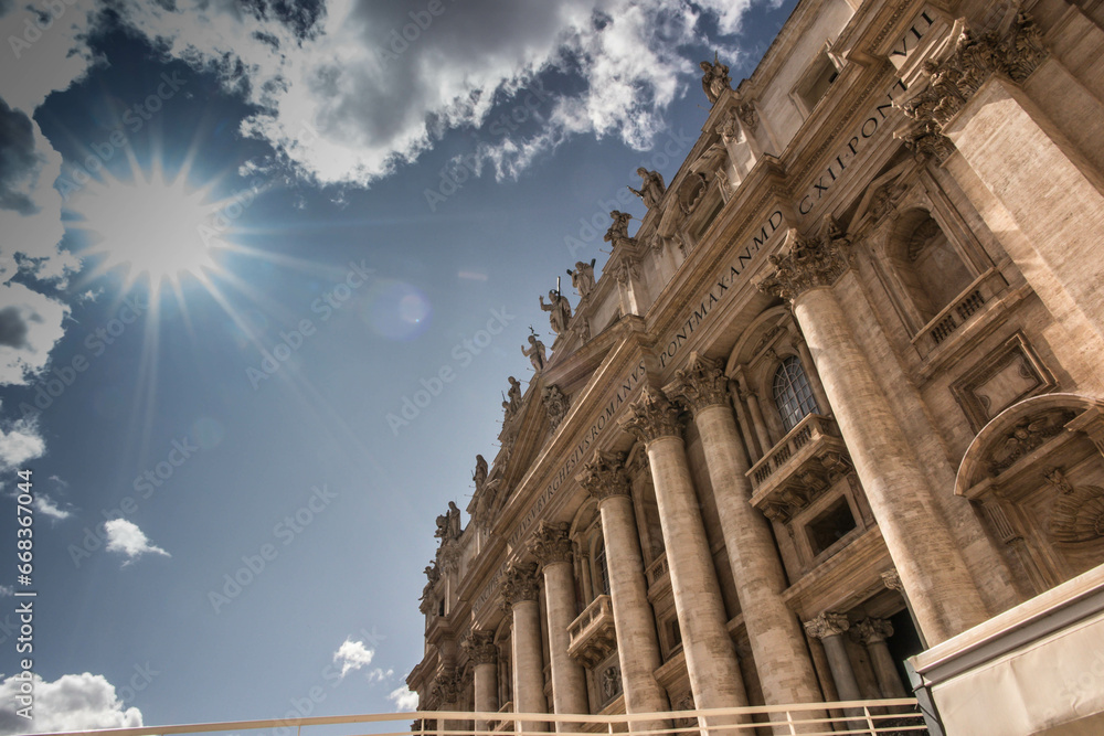 Blue sky, sun and white clouds over the Basilica of St. Peter in Rome, Italy.