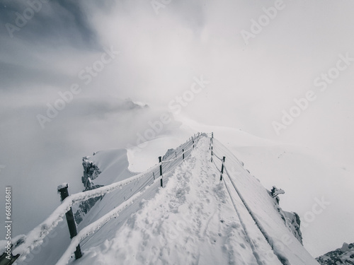 A dangerous snowy path disappears into thick fog