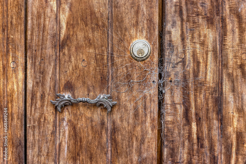 Rustikale Holztüre mit antiker Struktur mit Eisenschloss und Spinnweben photo