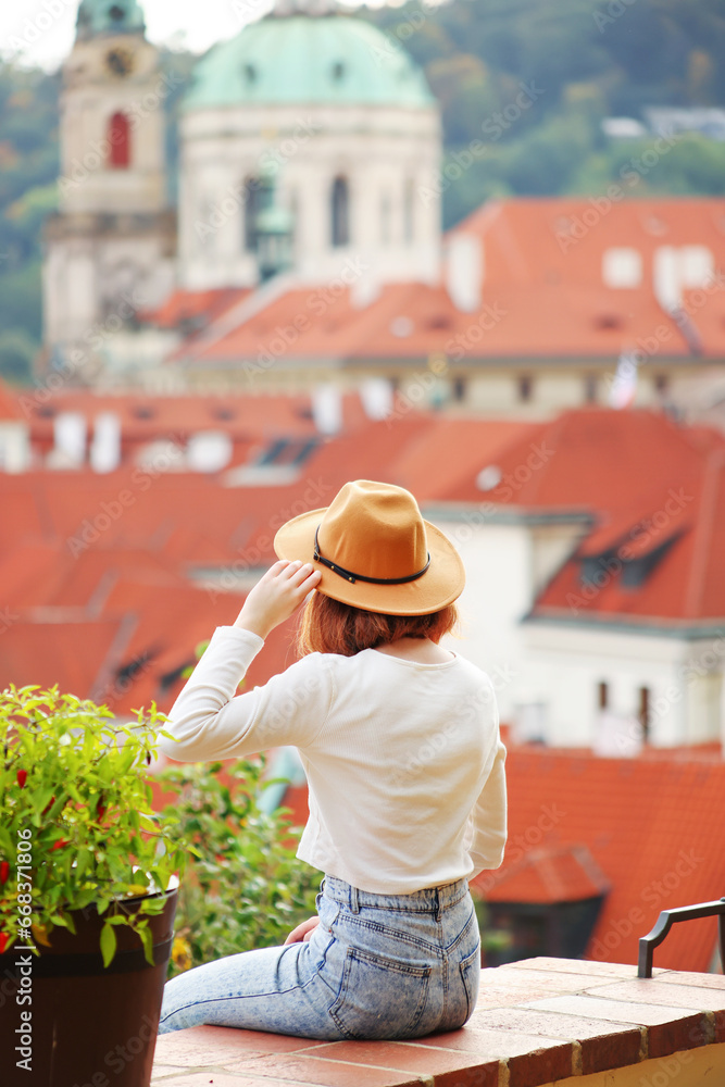 Girl in a beige hat, admiring the panorama of the city, Prague, Czech Republic