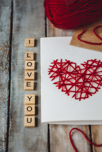 Beautiful wooden letterI love you on wooden background. Lovely cute handmade greeting card with red heart embroidering for Mothers or Saint Valentine's day, wedding or anniversary photo