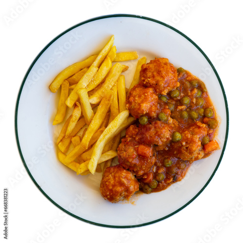 Delicious meat balls stewed in tomato sauce with green peas, carrot and potatoes served with french fries. Isolated over white background