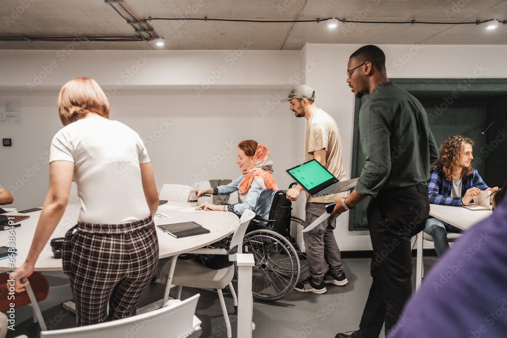 Diverse group of creative businesspeople preparing for work at the office. Start-up team getting ready for work