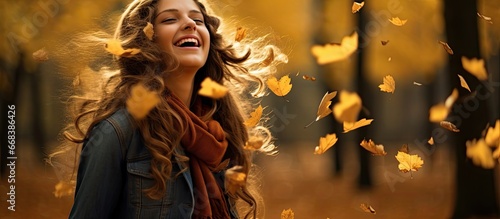 Fototapeta Naklejka Na Ścianę i Meble -  Girl enjoys autumn forest plays with leaves and listens to rustling
