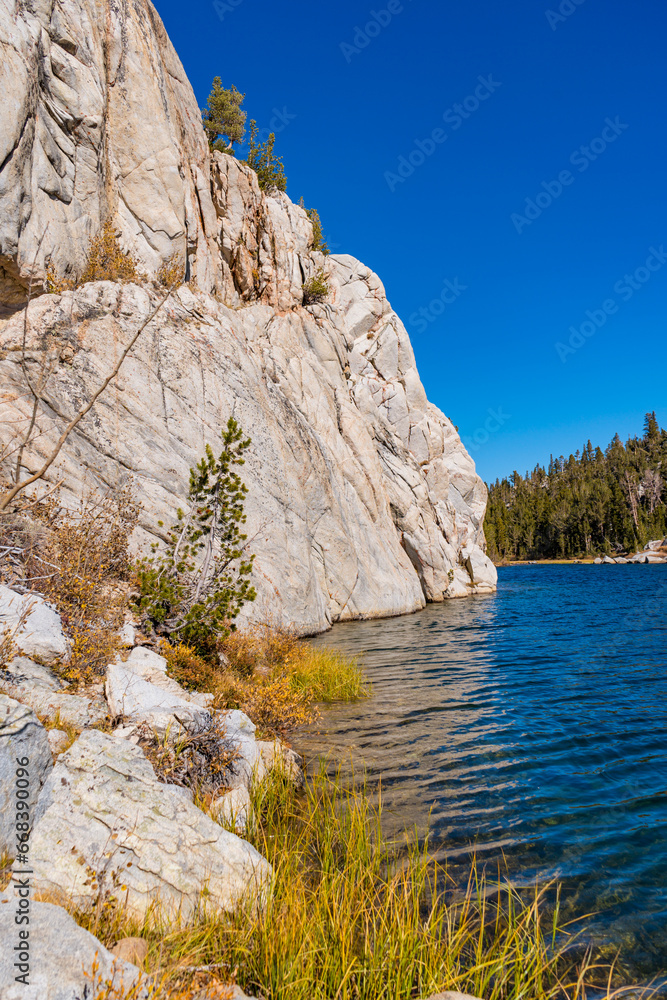 Hiking in Little Lakes Valley in the Eastern Sierra Nevada Mountains outside of Bishop, California. Alpine lakes, fall leaf colors, snow capped mountains and evergreen trees combine to make a pictures