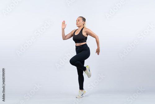 Active and fit physique senior woman in sportswear portrait in running posture isolated background. Healthy lifelong senior people with fitness healthy and sporty body care lifestyle concept. Clout