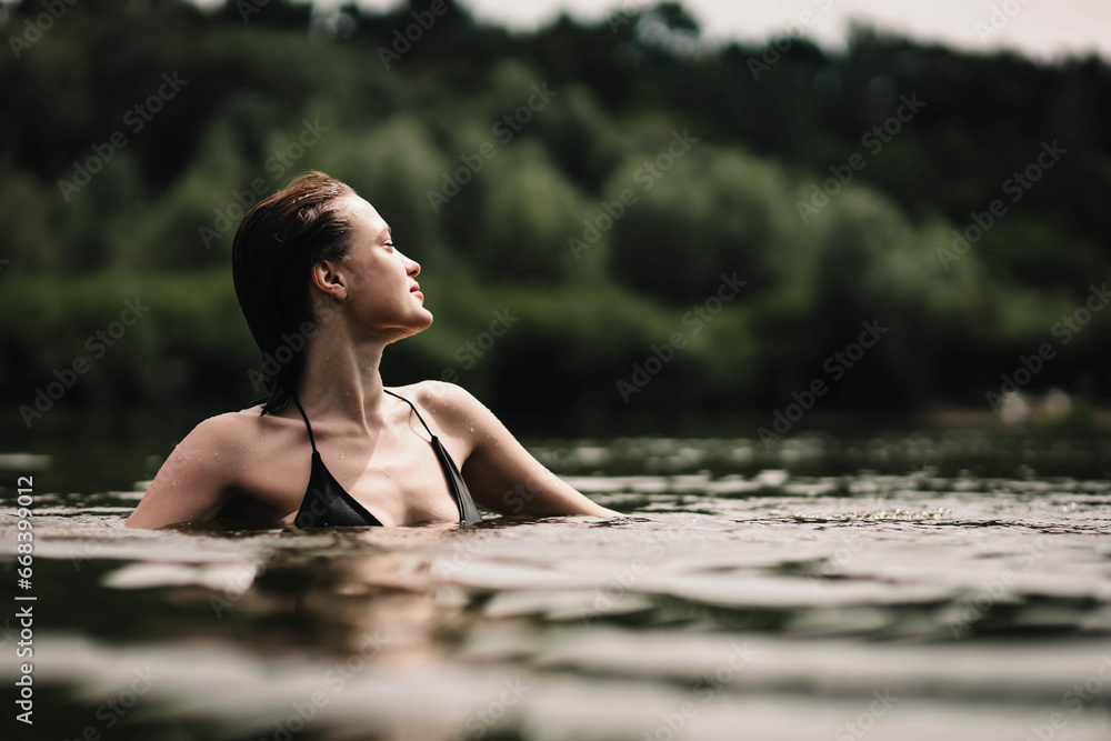 beautiful woman swims in the water of a lake river, swimming lessons. - obrazy, fototapety, plakaty 