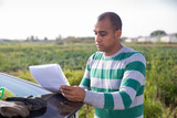 Portrait of male farmer signing documents near car outside