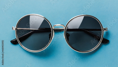 round hipster sunglasses on blue background in minimalist style