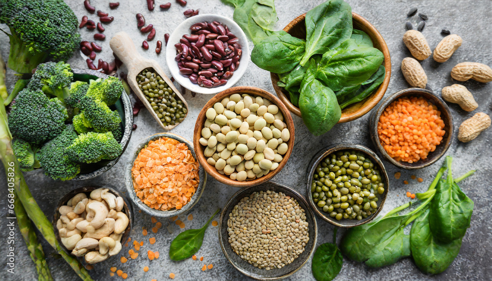 vegan protein source legumes beans lentils nuts broccoli spinach and seeds top view on stone table healthy vegetarian food - obrazy, fototapety, plakaty 