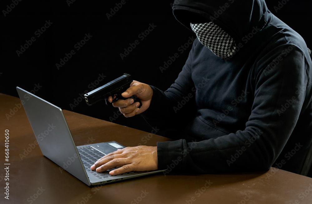 Hacker spy man one person in black hoodie sitting on a table looking computer laptop used login password attack security to circulate data digital in internet network system, night dark background. Hacker spy man one person in black hoodie sitting on a table looking computer laptop used login password attack security to circulate data digital in internet network system, night dark background.