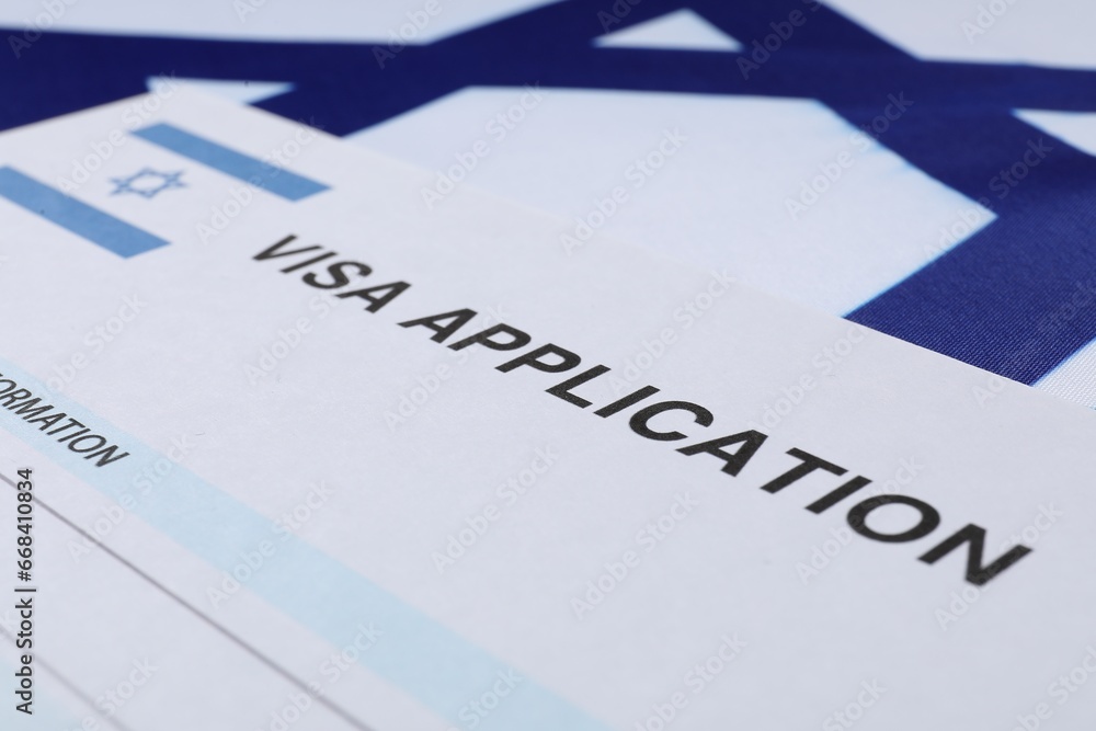 Immigration to Israel. Visa application form on flag, closeup Immigration to Israel. Visa application form on flag, closeup