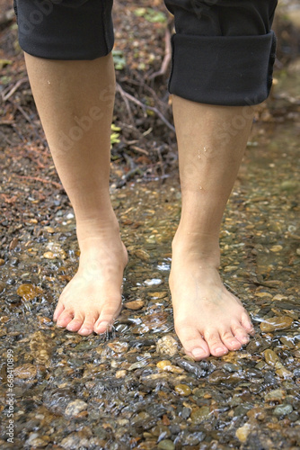 Standing barefooted in a shallow stream.