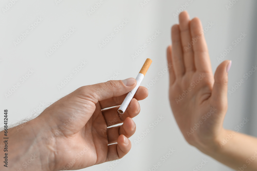 Stop smoking concept. Woman refusing cigarette on light background, closeup Stop smoking concept. Woman refusing cigarette on light background, closeup