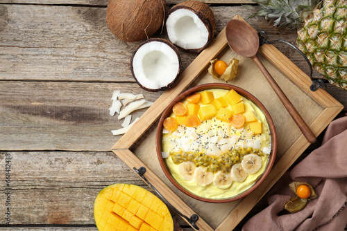 Tasty smoothie bowl with fresh fruits served on wooden table, flat lay. Space for text