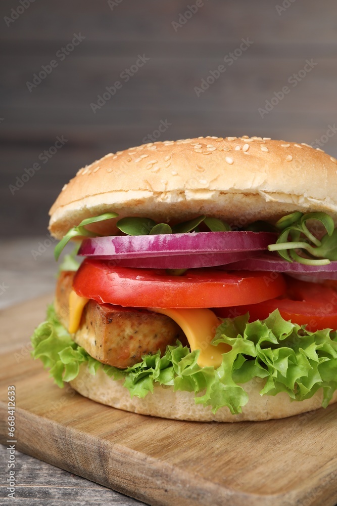 Delicious burger with tofu and fresh vegetables on table, closeup Delicious burger with tofu and fresh vegetables on table, closeup