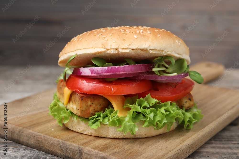 Delicious burger with tofu and fresh vegetables on table, closeup Delicious burger with tofu and fresh vegetables on table, closeup