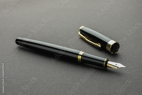 Stylish fountain pen with cap on grey background