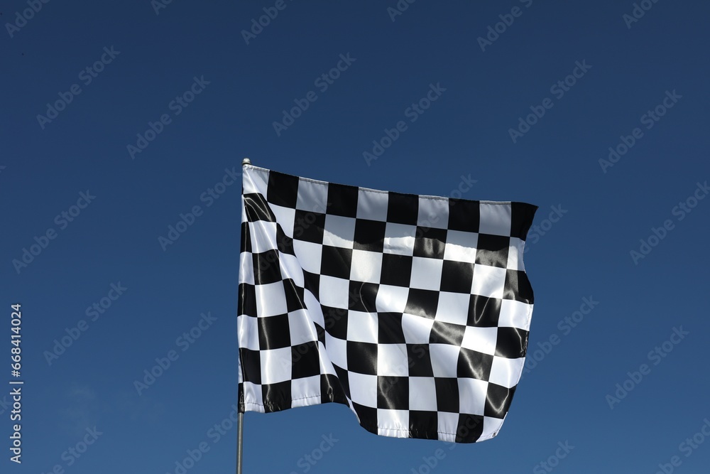 One checkered flag against blue sky outdoors, low angle view