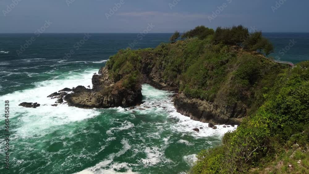 Drone view The beauty of Tanjung Karang Penganten on Gebyuran Beach, Kebumen, Central Java, Indonesia, a beach with beautiful coral cliffs, calm waves, hills and green trees Drone view The beauty of Tanjung Karang Penganten on Gebyuran Beach, Kebumen, Central Java, Indonesia, a beach with beautiful coral cliffs, calm waves, hills and green trees