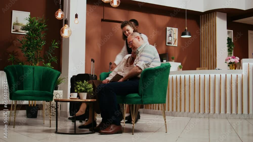 Retired couple falling asleep in lobby at five star hotel, napping while they wait for room check in. Senior people feeling tired and sleepy after travelling abroad, jetlag concept. Tripod shot. Retired couple falling asleep in lobby at five star hotel, napping while they wait for room check in. Senior people feeling tired and sleepy after travelling abroad, jetlag concept. Tripod shot.