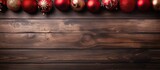 Rustic Christmas background features red balls on wooden surface