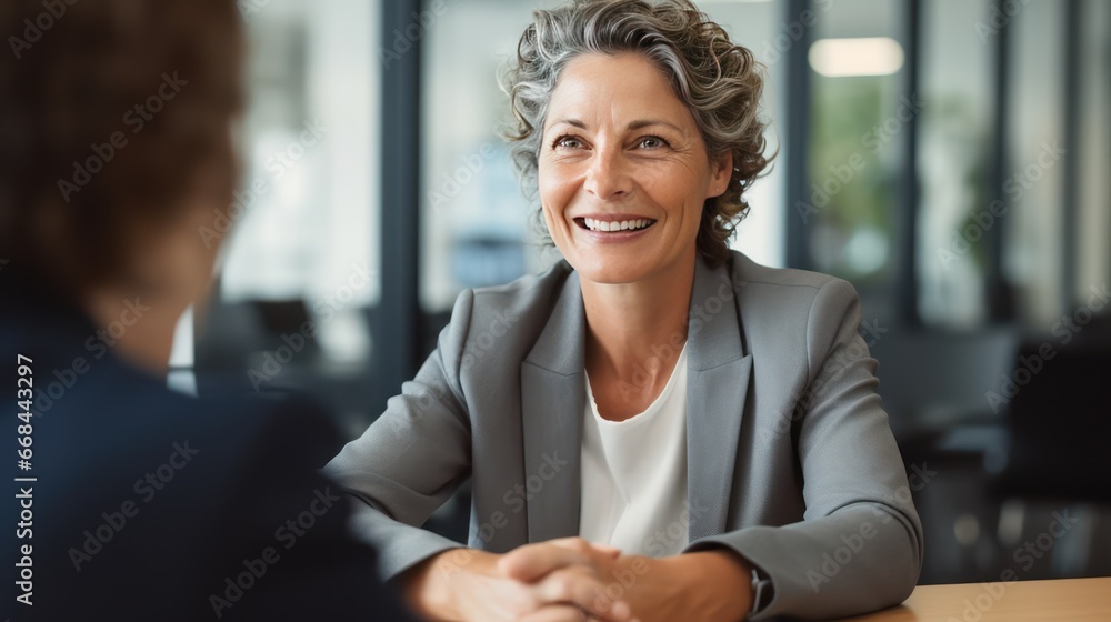 Middle - aged business woman manager with pleasure holding hands in recruitment and job interview, bank or insurance agent, lawyer at work. - obrazy, fototapety, plakaty 