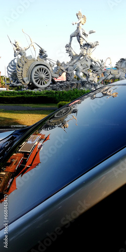 Ksatria Gatot Kaca Statue, at the airport area with car glass reflection photo