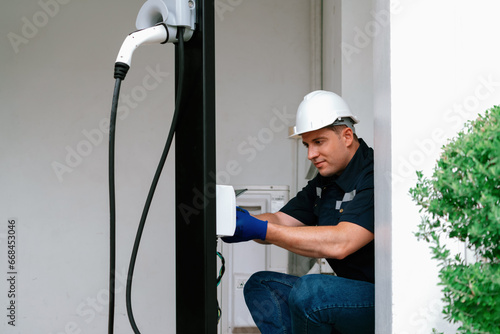 Foto Qualified technician install home EV charging station, providing maintenance service for electric vehicle's battery charging platform at home