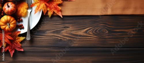 Thanksgiving table decoration with autumn leaves and ribbon on a wooden background
