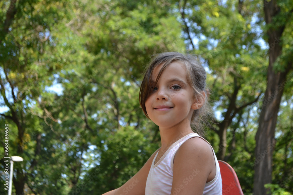 Cute kid girl 10 year old posing on nature background. Looking at camera Cute kid girl 10 year old posing on nature background. Looking at camera