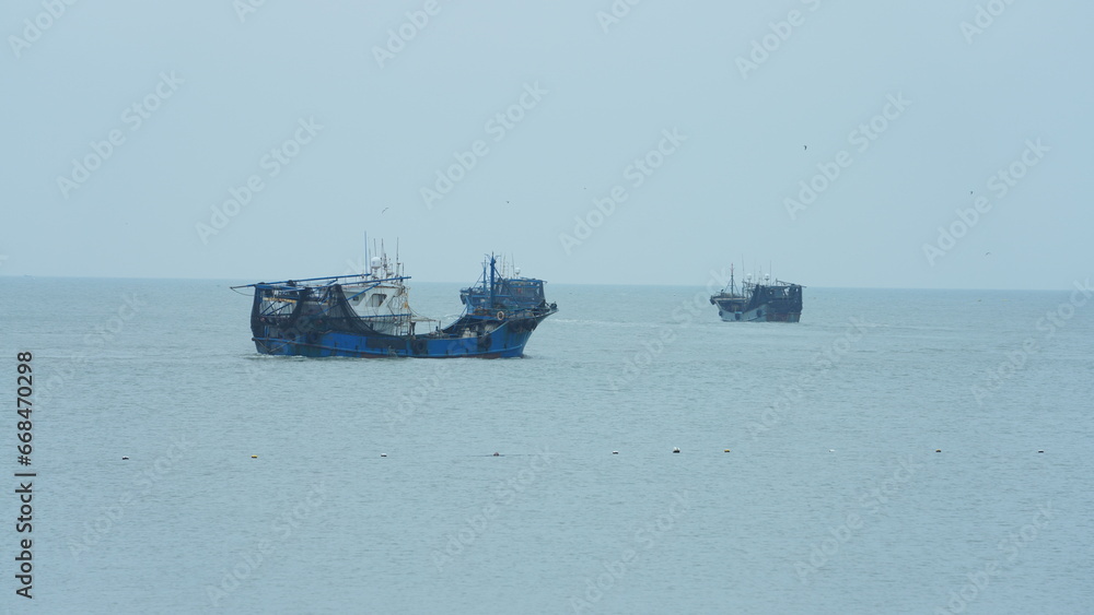 The peaceful sea view with the fishing boat sailing on it in the cloudy day The peaceful sea view with the fishing boat sailing on it in the cloudy day