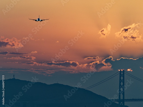 夕暮れの明石大橋と着陸してくる飛行機