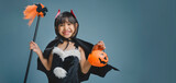 Little Asian girl dresses up in a Halloween costume.