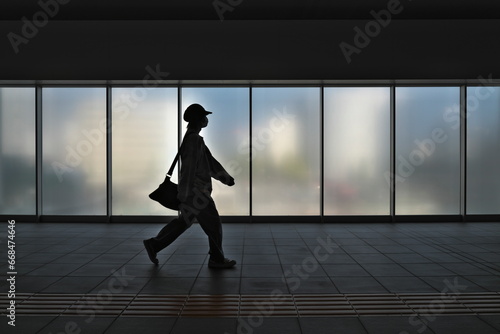 Niigata, Japan - October 25, 2023: Silhouette of people walking in front of frosted glass window 
