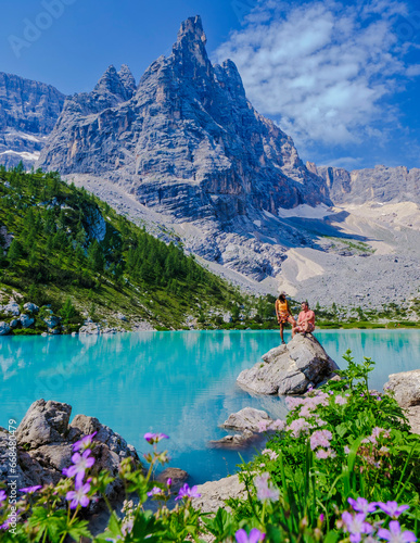 Couple of men and women visiting Lago di Sorapis in the Italian Dolomites,blue lake Lago di Sorapis,
