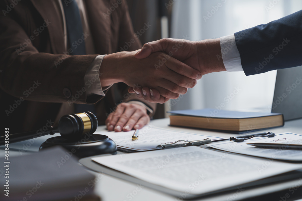 Lawyers shake hands with business people to seal a deal with partner lawyers or a lawyer discussing contract agreements, handshake concepts, agreements. - obrazy, fototapety, plakaty 