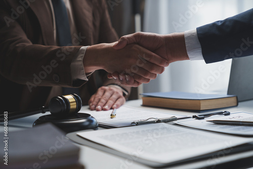 Lawyers shake hands with business people to seal a deal with partner lawyers or a lawyer discussing contract agreements, handshake concepts, agreements. photo