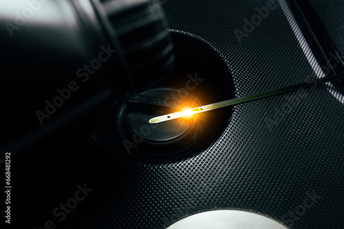 Car engine oil dipstick with reflective light on engine oil cap in engine compartment Car maintenance concept