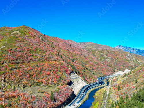 Aerial view of fall leaves, blue sky, and the winding highway alongside the Provo River in Provo Canyon, Utah, which lies in the Wasatch Mountain Range and stretches from Provo City to Heber City.  photo