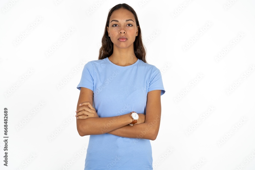 Serious pensive Beautiful girl wearing blue T-shirt feel like cool confident entrepreneur cross hands. Serious pensive Beautiful girl wearing blue T-shirt feel like cool confident entrepreneur cross hands.